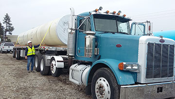 Truck carrying pipe section.