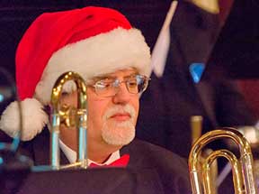 Man in santa hat with instrument.