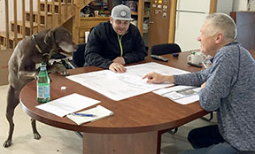 Peter and Clark look over some plans with supervision from Charlie, one of the office dogs