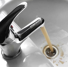 faucet with brown water running from it into sink