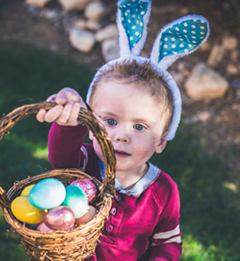 kid with bunny ears and easter basket of eggs